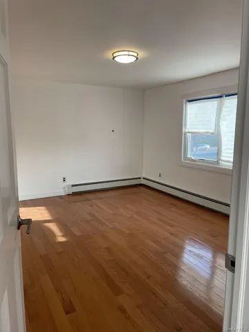 a view of a room with wooden floor and window