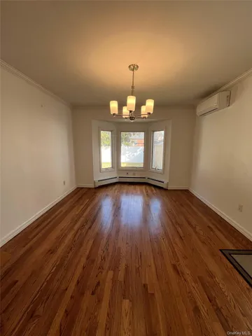 a view of a room with wooden floors and chandelier