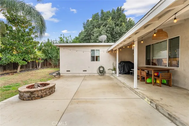 a view of a backyard with table and chairs and potted plants