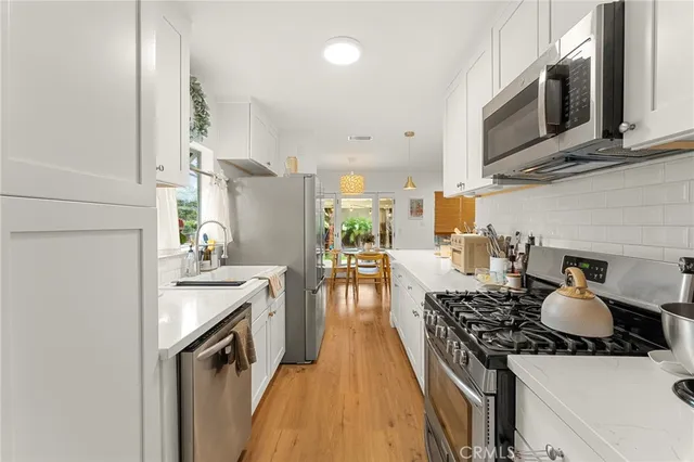 a kitchen with a stove and a white wooden cabinets