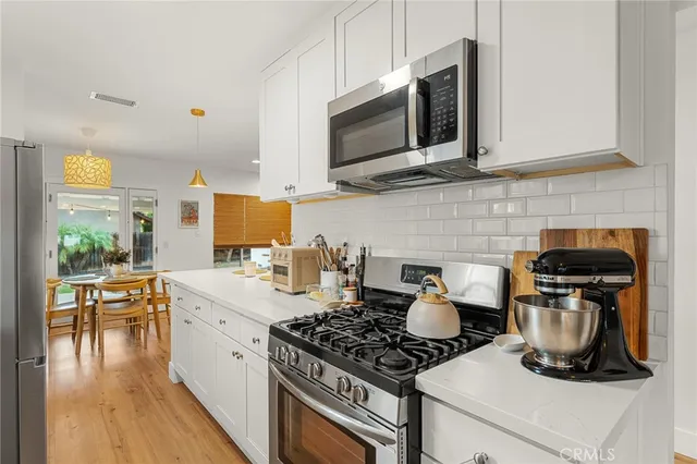 a kitchen with a stove and a wooden floor