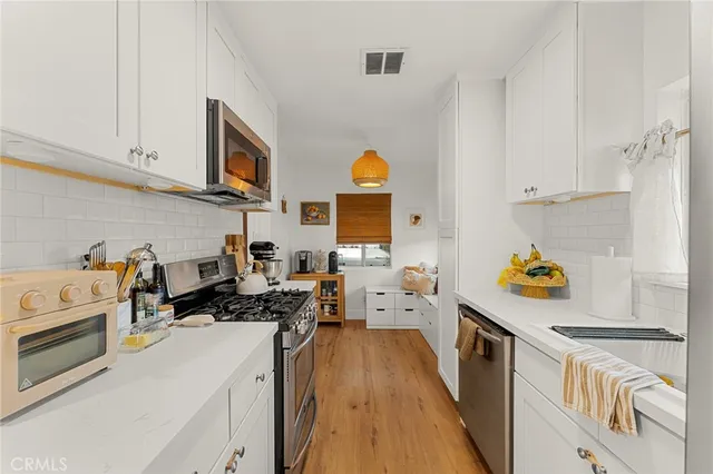 a kitchen with stainless steel appliances a stove a sink and a refrigerator