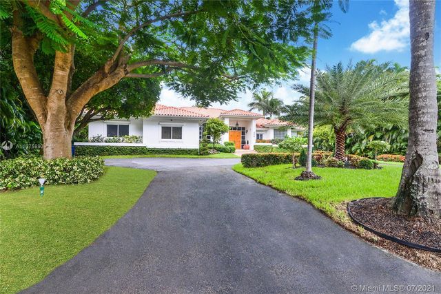 a front view of a house with a yard and trees