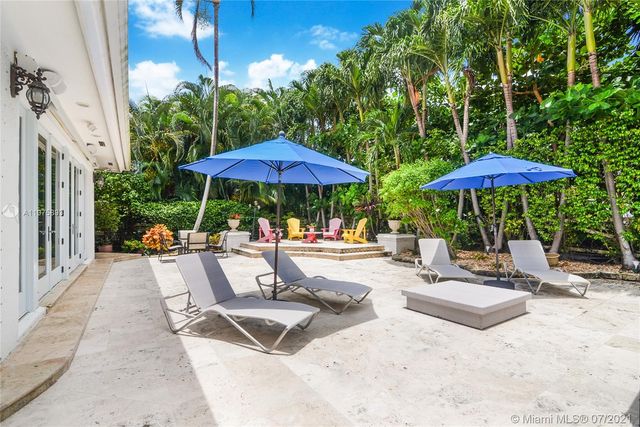a view of a patio with a table and chairs under an umbrella