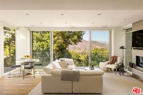 a living room with fireplace furniture and a large window