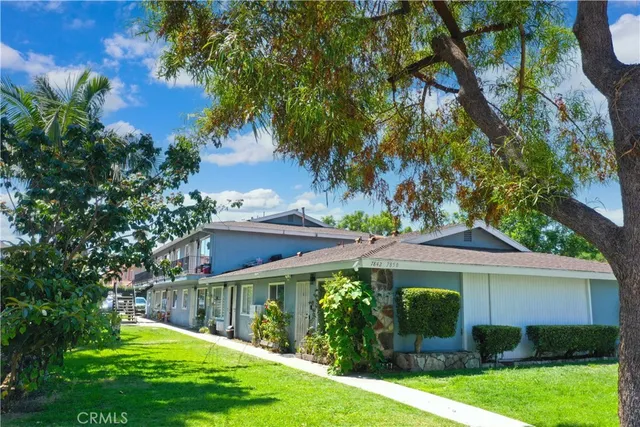 a view of a house with backyard and a tree