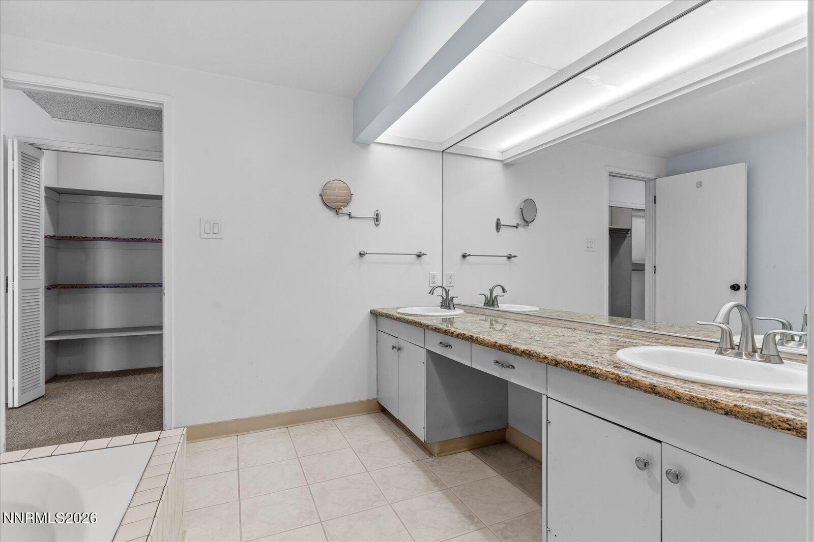 1200 Riverside Drive, Unit 1229 Reno, NV 89503 - Photo 39 of 51 a bathroom with a granite countertop sink and a mirror