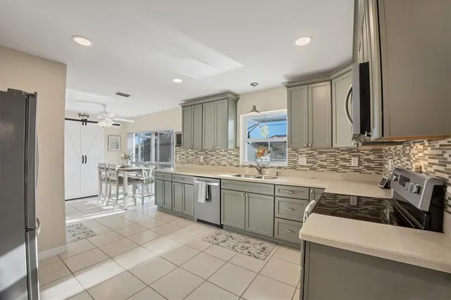 a kitchen with appliances cabinets and chairs