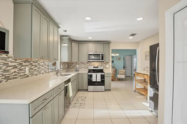 a kitchen with stainless steel appliances granite countertop a refrigerator and a stove top oven