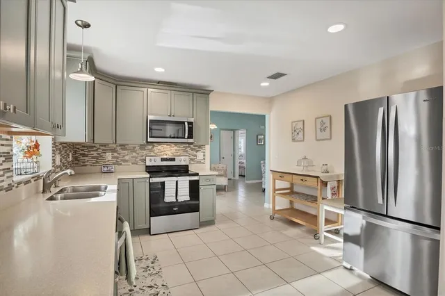 a kitchen with stainless steel appliances granite countertop a refrigerator and a stove top oven