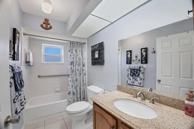 a bathroom with a granite countertop sink toilet a mirror and shower