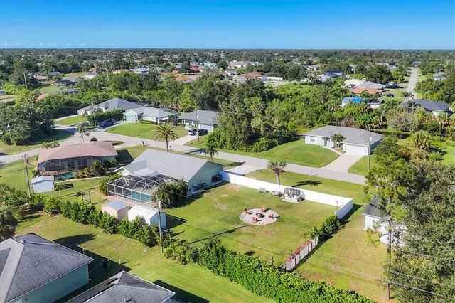 an aerial view of residential houses with outdoor space and trees