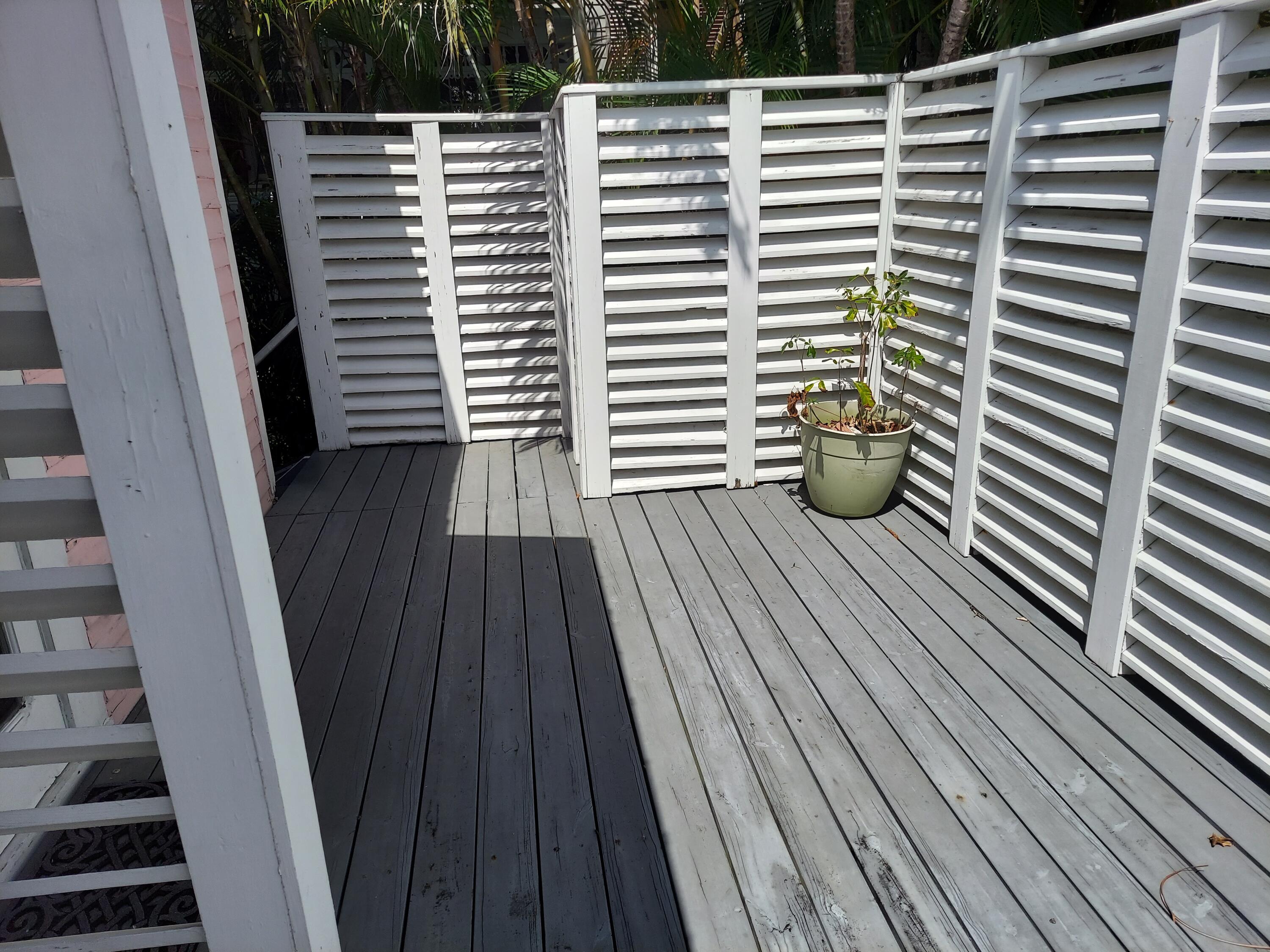 315 William Street Key West, FL 33040 - Photo 8 of 19 a view of a balcony with wooden floor and fence and a window