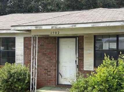 1502 Hall Street Bainbridge, GA 39819 - Photo 4 of 15 a stone house with potted plants in front of door