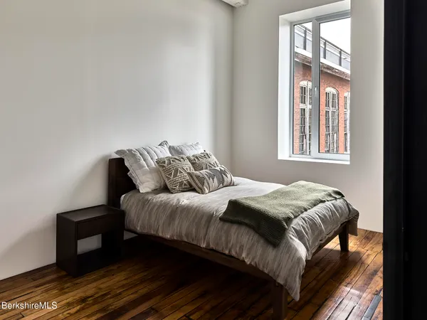 a bedroom with a bed and wooden floor