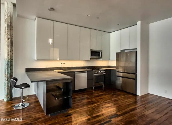 a kitchen with stainless steel appliances granite countertop a stove a refrigerator and a microwave