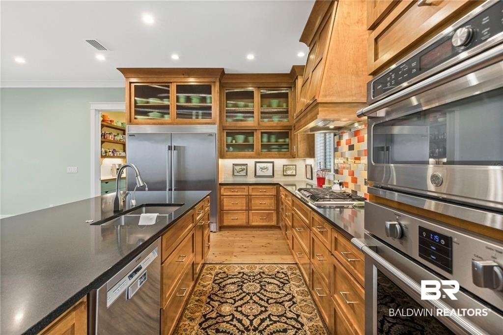 2730 Gator Road Mobile, AL 36605 - Photo 10 of 42 Kitchen with wood finish cabinetry, stainless steel appliances, glass fronted cabinets, backsplash, and recessed lighting
