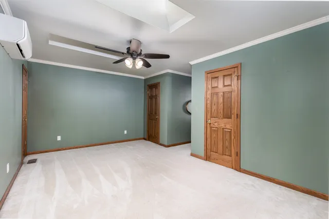 a view of an empty room with a chandelier fan