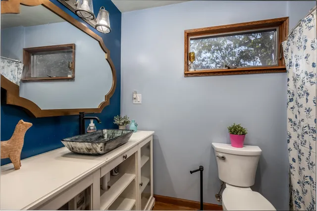 a bathroom with a sink mirror and toilet