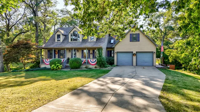 a front view of a house with a yard and trees