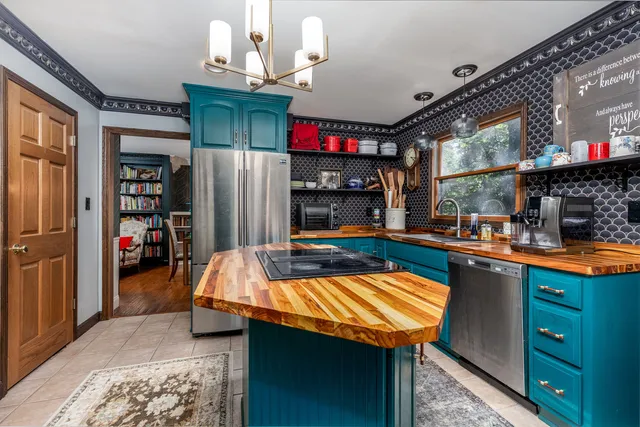 a room with stainless steel appliances kitchen island granite countertop furniture and a fireplace