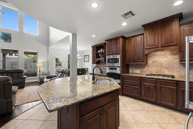 a kitchen with stainless steel appliances granite countertop a sink counter space and cabinets