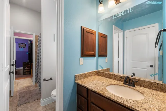 a bathroom with a granite countertop sink and a mirror