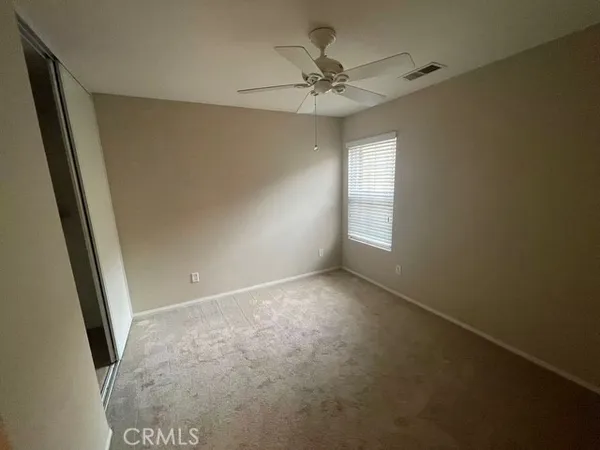 en empty room with windows and fan