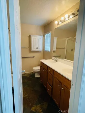 a bathroom with a double vanity sink toilet and mirror