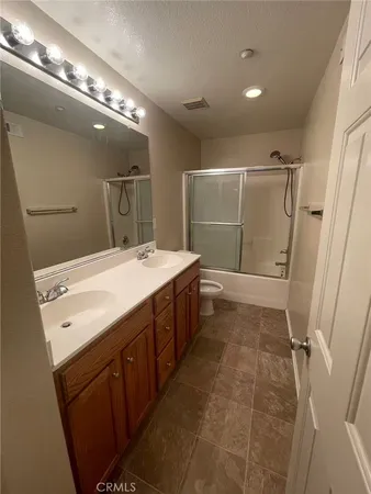 a bathroom with a double vanity sink mirror and shower