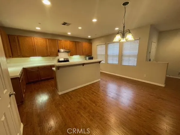 a kitchen with stainless steel appliances granite countertop a sink a stove and a wooden floors