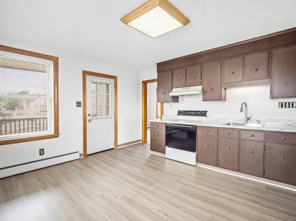 a kitchen with granite countertop a stove a sink and a refrigerator