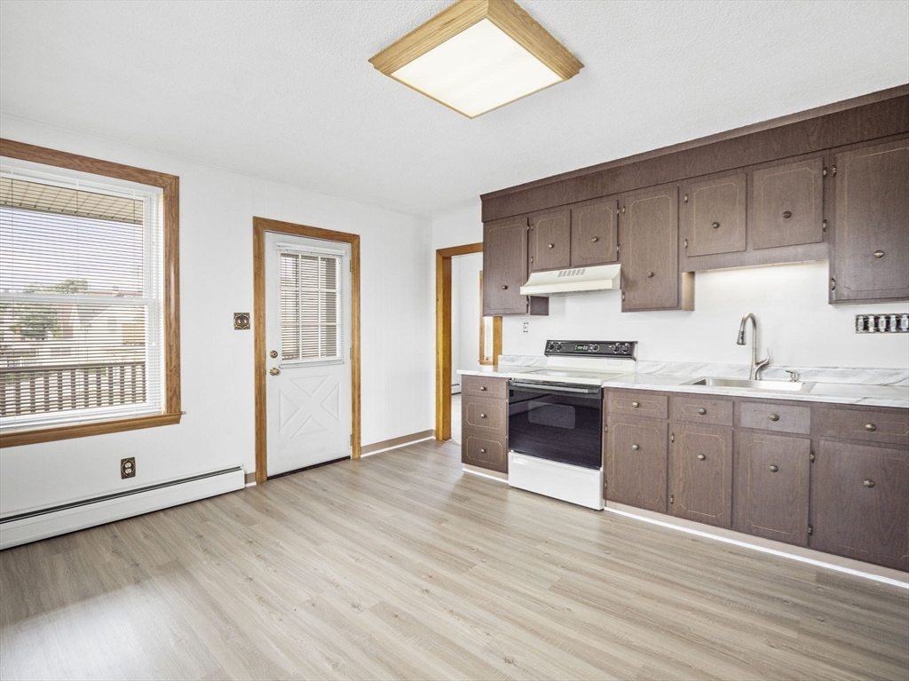69 Stowers Street, Unit 2 Revere, MA 02151 - Photo 2 of 17 a kitchen with granite countertop a stove a sink and a refrigerator