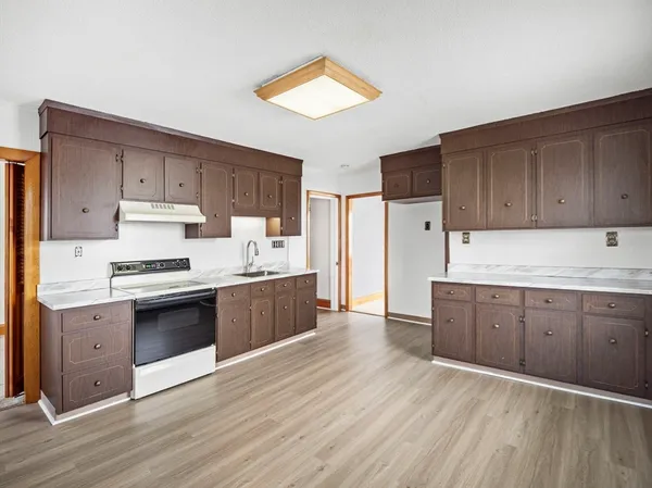 a kitchen with granite countertop wooden floors and white stainless steel appliances