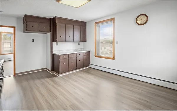 a view of an empty room with window and wooden floor