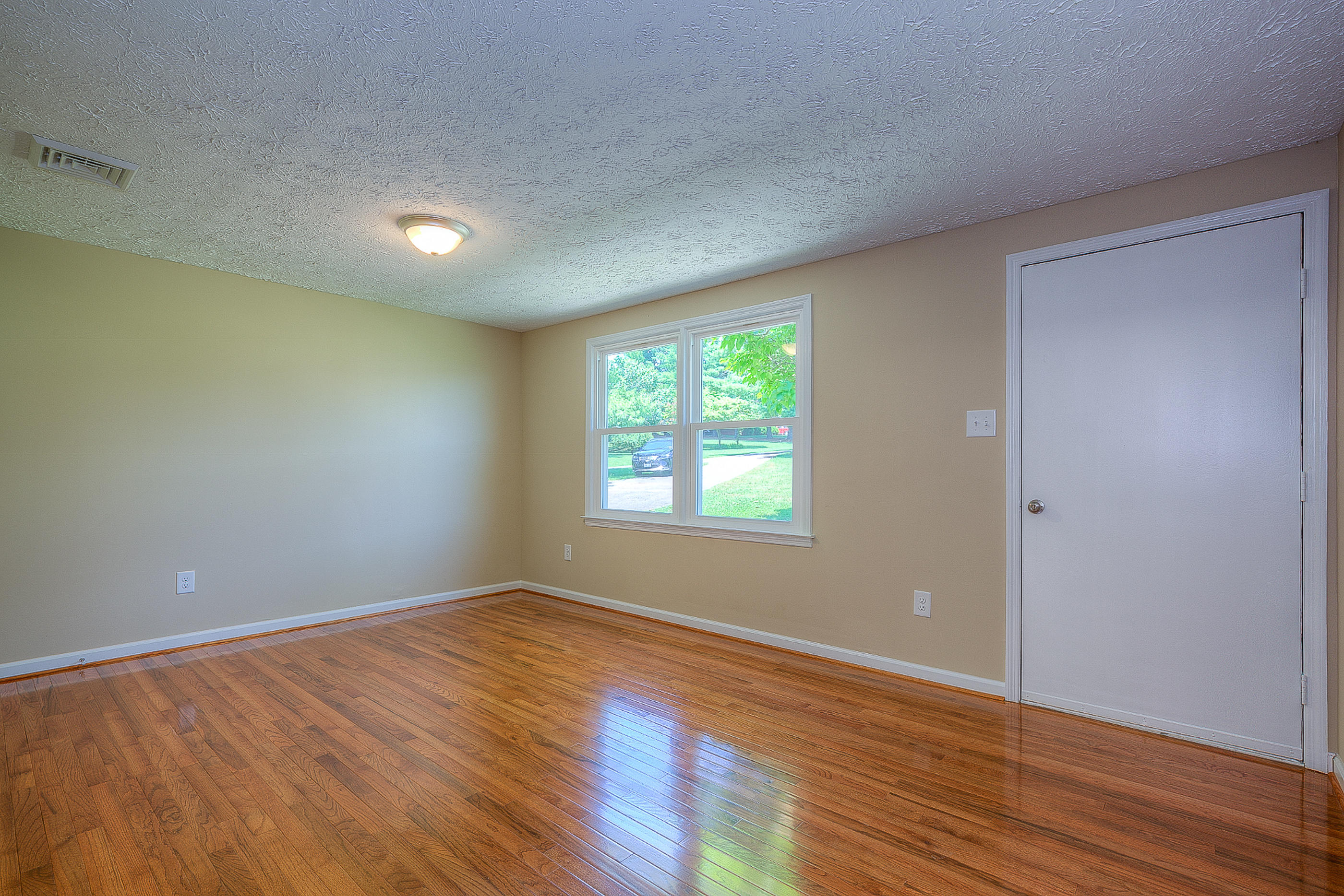 2509 Rutrough Road Southeast Roanoke, VA 24014 - Photo 14 of 28 a view of an empty room with wooden floor and a window