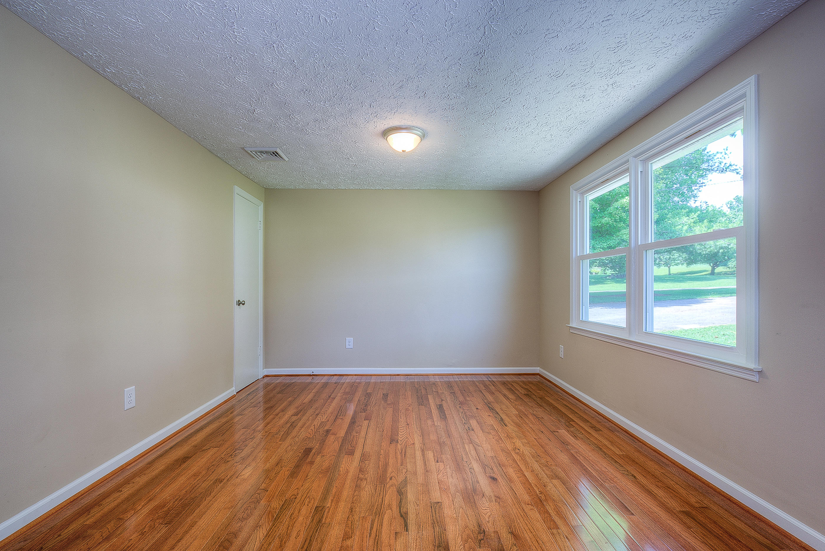 2509 Rutrough Road Southeast Roanoke, VA 24014 - Photo 15 of 28 an empty room with wooden floor and windows