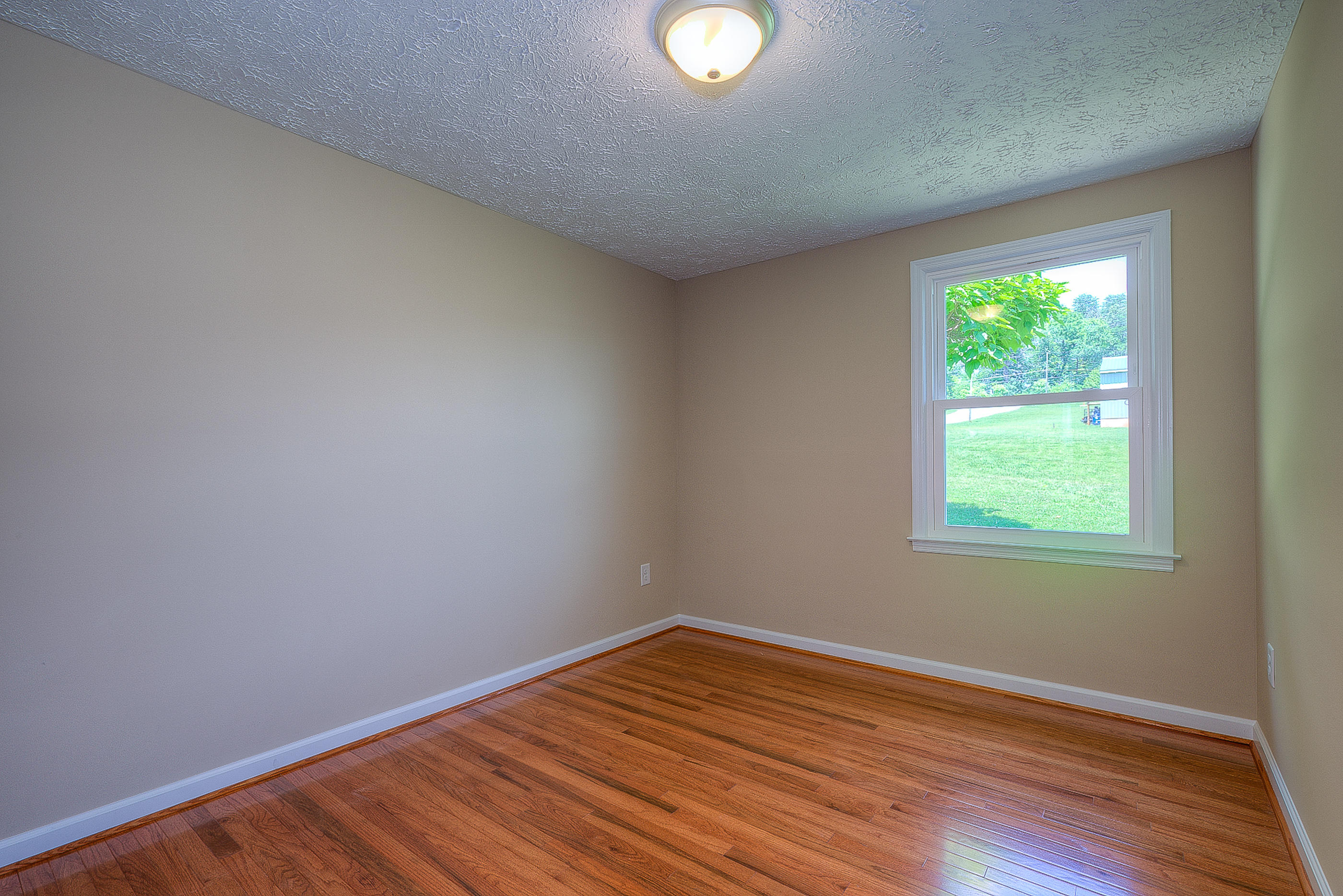 2509 Rutrough Road Southeast Roanoke, VA 24014 - Photo 18 of 28 an empty room with wooden floor and windows