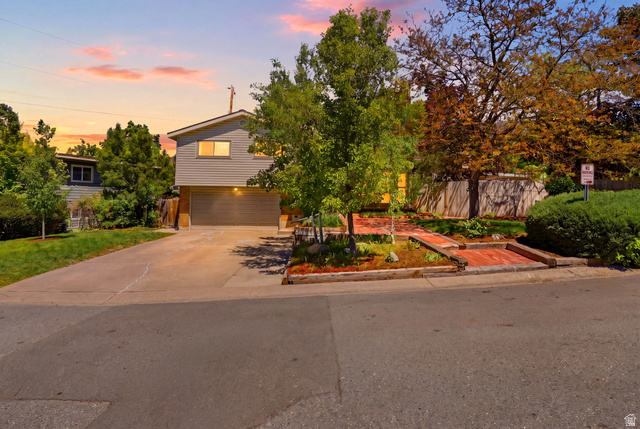 4245 3320 East Holladay, UT 84124 - Photo 2 of 51 Split-level exterior featuring gray siding and a prominent two-car garage