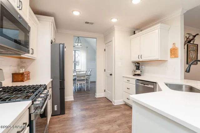 a kitchen with white cabinets and stainless steel appliances