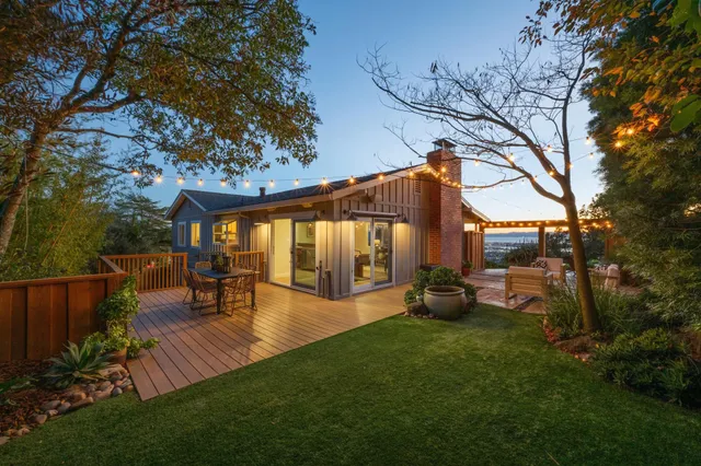 a view of a deck with furniture and a yard