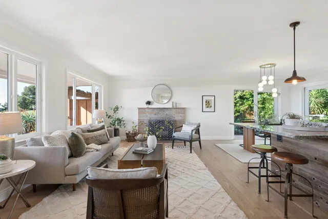 a living room with furniture a fireplace and a large window