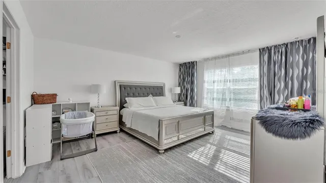 a bedroom with a bed and a large window