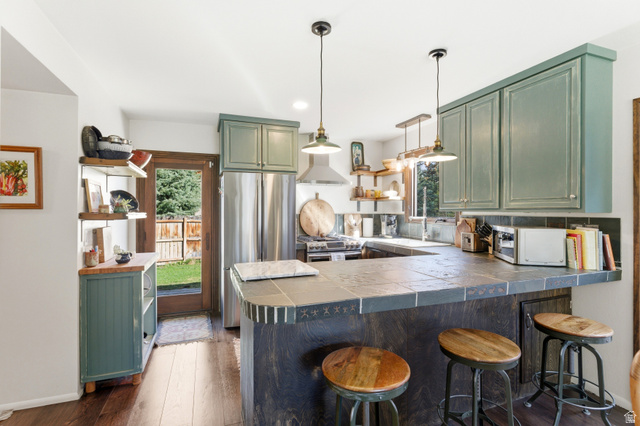 2635 Little Kate Road, Unit 21 Park City, UT 84060 - Photo 10 of 39 Kitchen with green cabinets, a peninsula, dark wood finished floors, stainless steel appliances, and open shelves