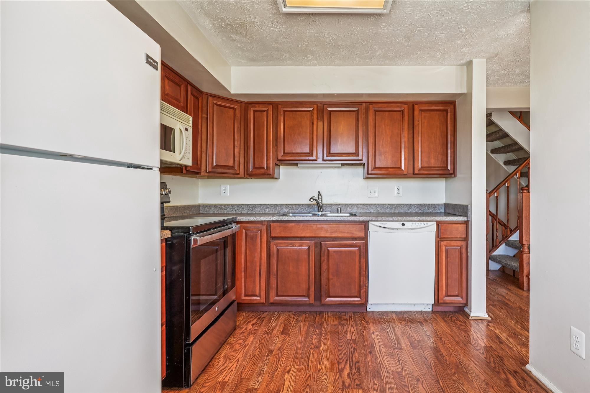 14740 Winding Loop Woodbridge, VA 22191 - Photo 15 of 59 a kitchen with granite countertop wooden cabinets a sink and dishwasher