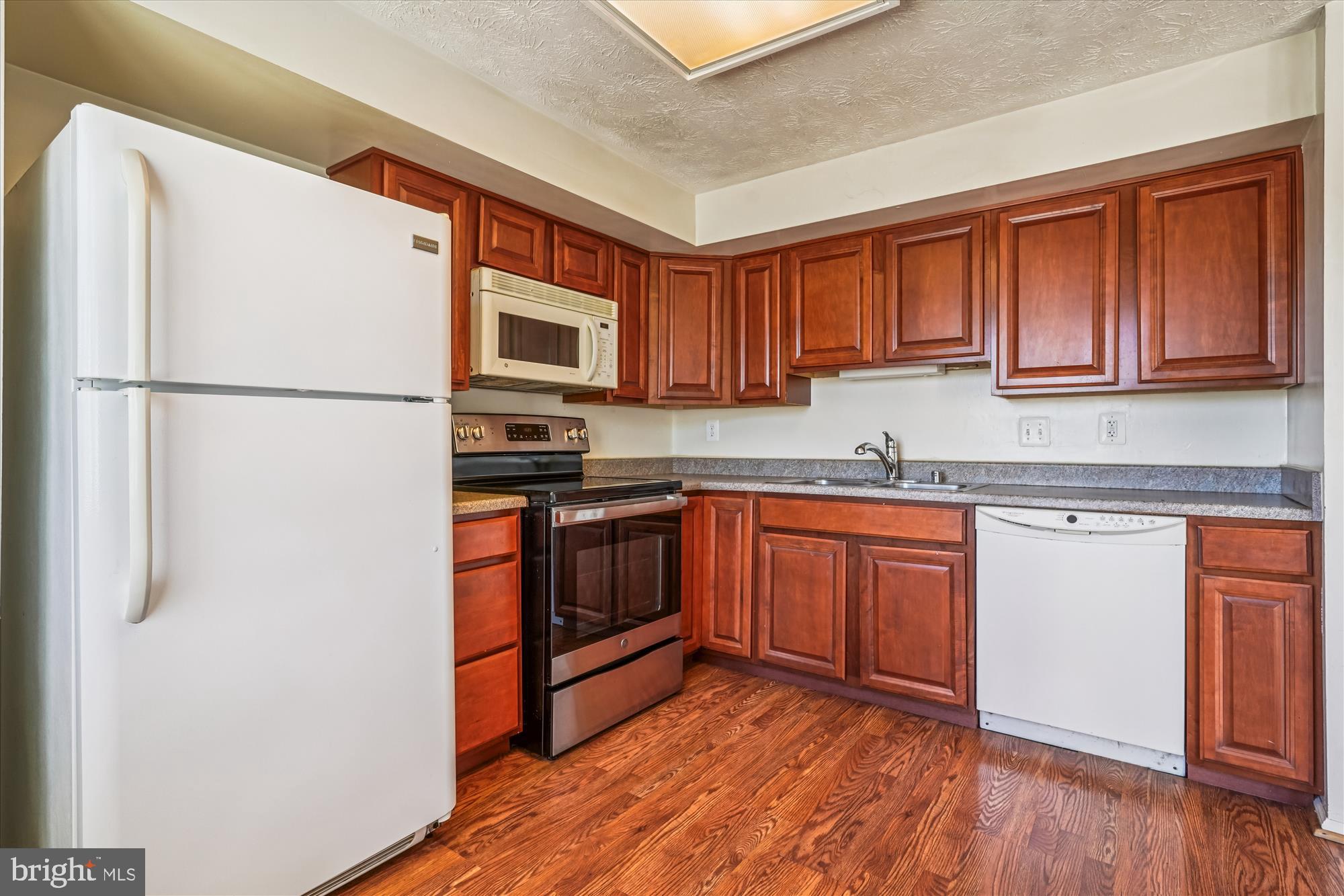 14740 Winding Loop Woodbridge, VA 22191 - Photo 16 of 59 a kitchen with stainless steel appliances granite countertop a refrigerator sink and stove