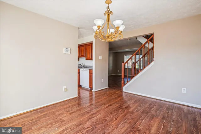 a view of an empty room with wooden floor and window