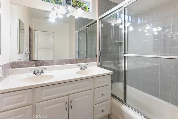 a bathroom with a sink shower and a mirror