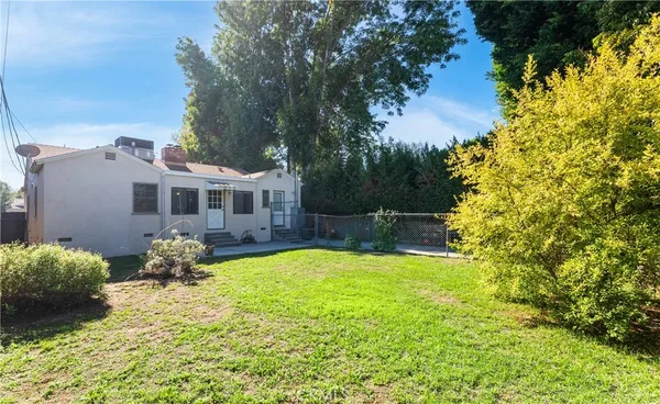 a backyard of a house with yard and outdoor seating