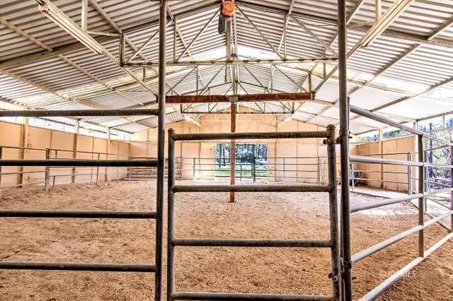 a large bedroom with a bed a table and chairs with wooden floor
